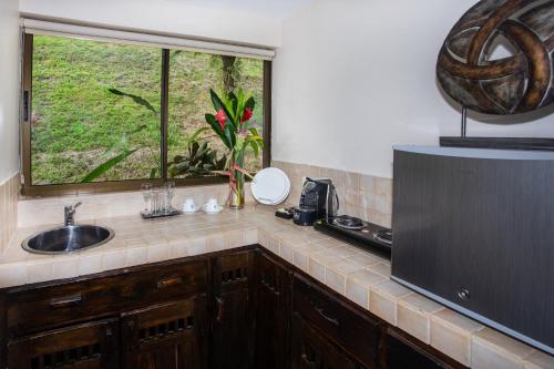 a kitchen with a sink and a window at Tiki Villas Rainforest Lodge - Adults Only in Uvita