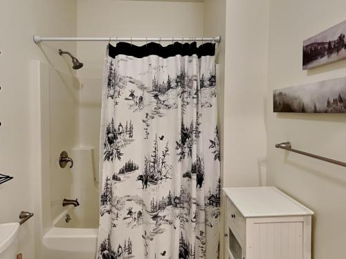 a bathroom with a black and white shower curtain at Black Pines Lodge in Hazelhurst