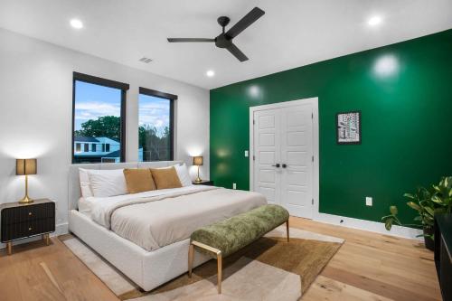 a green bedroom with a bed and a green wall at The ATX South Lamar Creekside Retreat with a pool in Austin