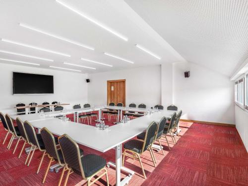 a conference room with a large white table and chairs at Movenpick Resort and Spa Fruske Terme in Vrdnik