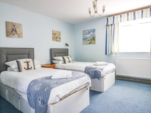 a bedroom with two beds and a window at Squirrels Dray in Saint Goran