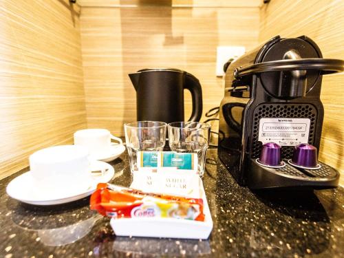 a table with a coffee maker and glasses on it at ibis Styles Singapore Albert in Singapore