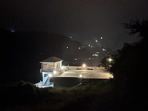 a night time view of a building with a parking lot at Hotel Comfort Hill in Abbottābād