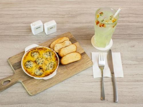a table with a plate of food and bread and a drink at ibis Styles Singapore Albert in Singapore