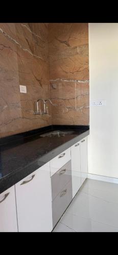 a kitchen with white cabinets and a counter top at Prime pearl villa in Thūr