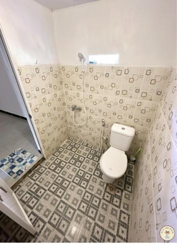 un baño con inodoro y ducha en Kuta Vibe House, en Kuta Lombok