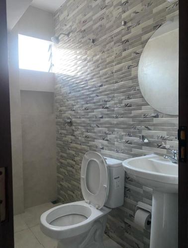 a bathroom with a toilet and a sink at Amaca Hostal in Santa Cruz de la Sierra