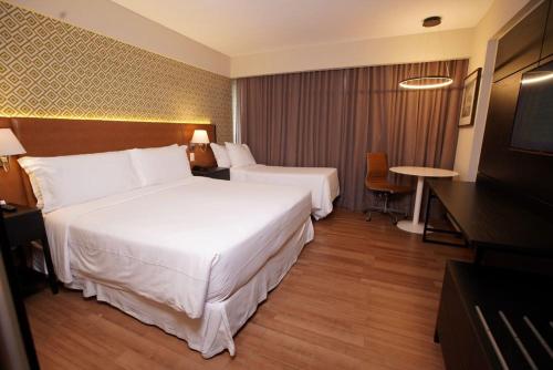 a hotel room with two beds and a television at Hotel da Bahia by Wish in Salvador