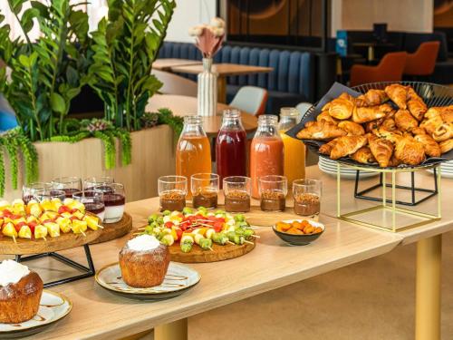 a table filled with different types of food and pastries at Mercure Dunkerque Centre Gare in Dunkerque