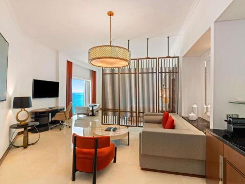 a living room with a couch and a table at Rixos Marina Abu Dhabi in Abu Dhabi