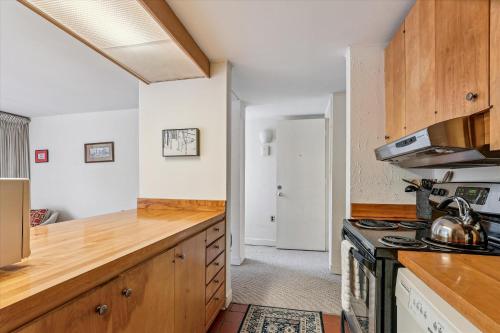 a kitchen with wooden cabinets and a stove top oven at Notchbrook 17ABC in Stowe