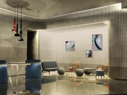 a lobby with chairs and a table in a building at ibis Styles Semarang Simpang Lima in Semarang
