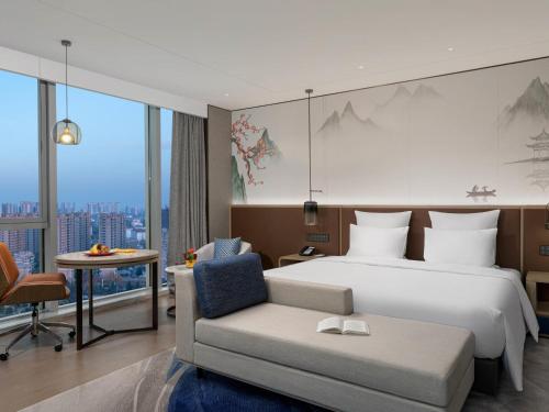 a hotel room with a bed and a chair at Pullman Huai'an in Huai'an
