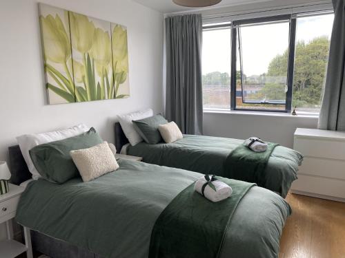 a bedroom with two beds and a window at Executive North London Southgate Serviced Apartment - Contractors Ready in East Barnet
