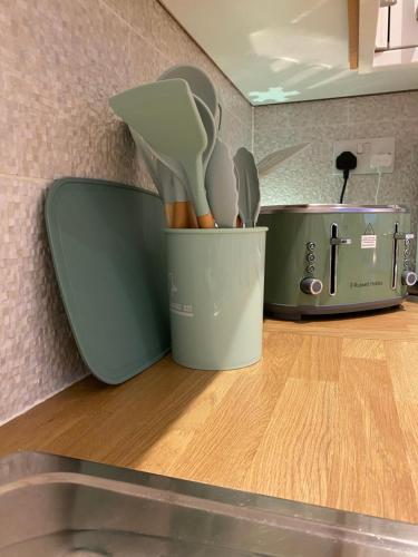 a container of utensils is sitting on a counter at Executive North London Southgate Serviced Apartment - Contractors Ready in East Barnet