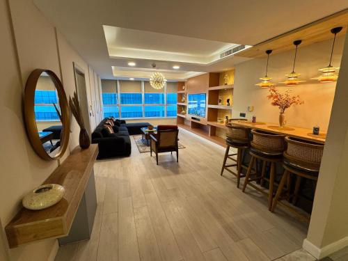 a large living room with a couch and a bar at Centaurus Mall 2BR Xbox Pool, Gym & City View in Islamabad