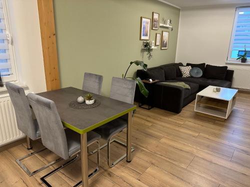 a living room with a table and a couch at Ferienwohnung Schwalbennest in Eisfeld