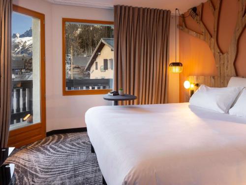 a hotel room with a large bed and a window at ibis Styles Les Houches Chamonix in Les Houches