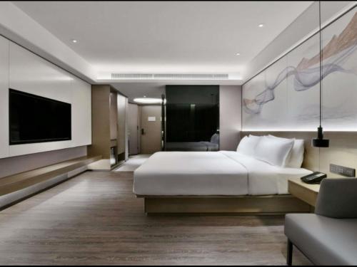 a hotel room with a bed and a flat screen tv at Mercure Guilin Hi Tech Zone in Guilin