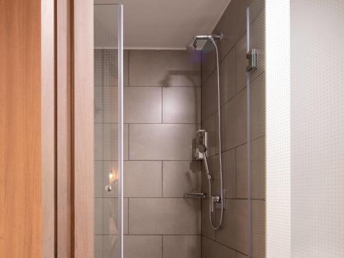 un bagno con doccia con porta in vetro di ibis Santa Cruz de la Sierra a Santa Cruz de la Sierra
