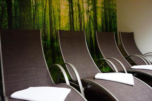 an empty row of chairs with a bamboo mural on the wall at Hotel Sonne Lienz in Lienz