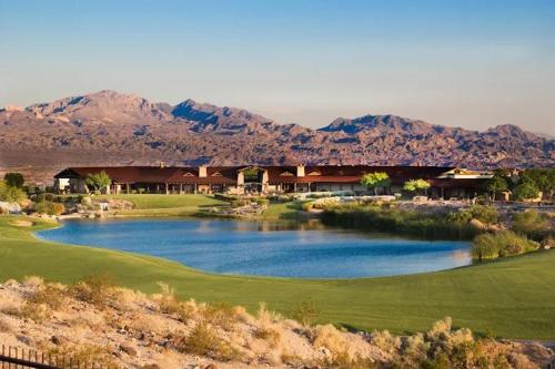 a golf course with a lake and mountains in the background at Days Inn by Wyndham Bullhead City in Bullhead City