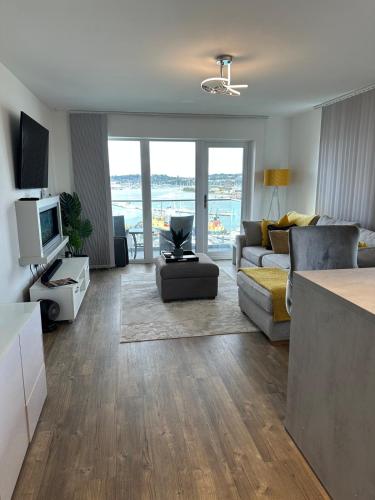 a living room with a couch and a tv at Waterfront - long stay apartment in Southampton