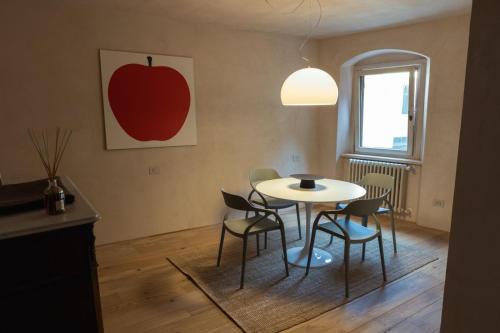 a dining room with a table and chairs and an apple painting at POPPI garden in Poppi