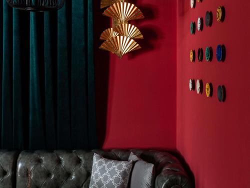 a living room with a couch and red walls at Mövenpick Samarkand in Samarkand