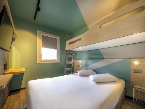 a bedroom with a bed and a bunk bed with a ladder at ibis budget Forbach Centre in Forbach