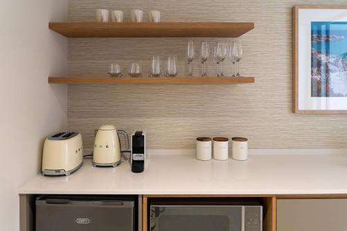 een keuken met een aanrecht met glazen en apparatuur bij Satori Lodge by Bliss Collection in Kaapstad