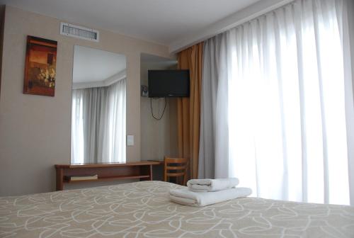 a hotel room with a bed with towels on it at Hotel Benevento in La Plata