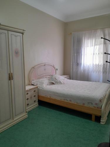 a bedroom with a bed and a dresser and a window at Casa martil in Martil