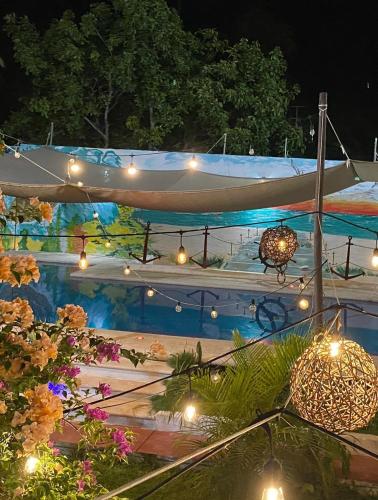 a swimming pool at night with lights and a boat at Hotel Albatros in Isla Aguada