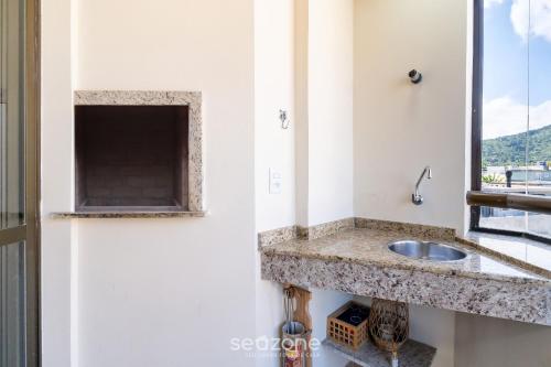 a kitchen counter with a sink and a window at Apto com Vista Mar a 214m da Praia - BLU0206 in Florianópolis