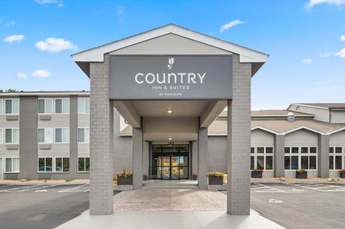 a building with a sign that reads country max suites at Country Inn & Suites by Radisson, Near The National Sports Center, Coon Rapids, MN in Coon Rapids
