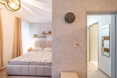 a bedroom with a bed and a clock on the wall at Klínovec ski apartments in Loučná pod Klínovcem