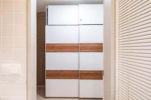 a closet with white and wooden dividers at Klínovec ski apartments in Loučná pod Klínovcem
