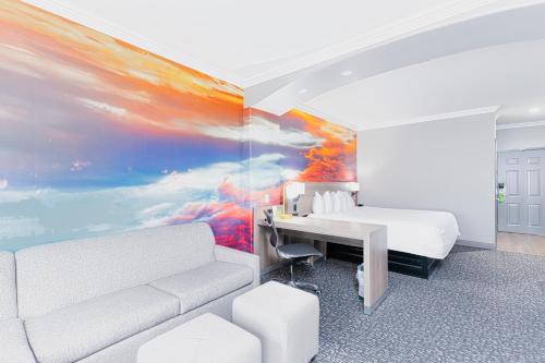 a bedroom with a bed and a desk and a painting at La Quinta by Wyndham Oklahoma City - Moore in Moore