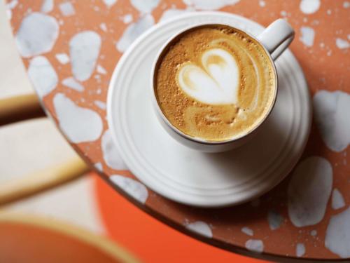 a cup of coffee with a heart on a plate at 21c Museum Hotel St Louis in Saint Louis