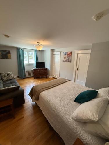 a bedroom with a large bed and a couch at Midstream Manor Unit 3, Studio in St. John's