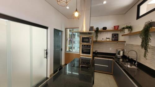 une grande cuisine avec un comptoir en verre dans l'établissement Casa de 3 quartos em Franca - Piscina aquecida, banheira, conforto e lazer, à Franca