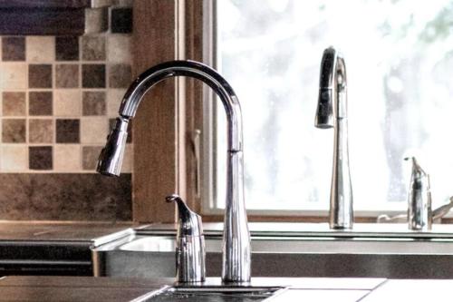 a kitchen sink with two faucets and a window at Chalet Boreal Mont-Blanc in Mont-Blanc
