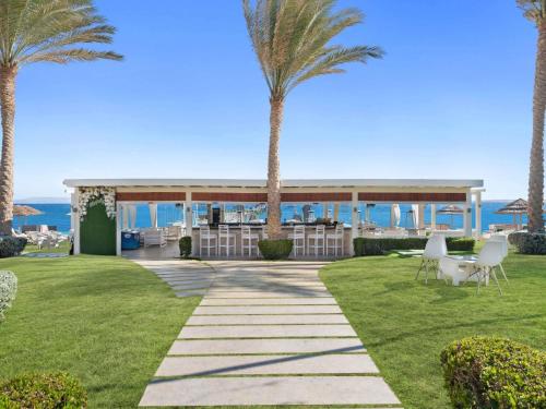 a resort with palm trees and a gazebo at Rixos Sharm El Sheikh - Adults Only 18 Plus in Sharm El Sheikh