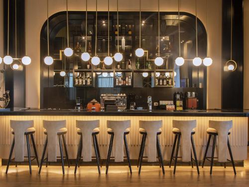 a bar with white stools in a room at Rixos Sharm El Sheikh - Adults Only 18 Plus in Sharm El Sheikh