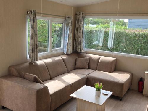 a living room with a brown couch and a table at de Schelphoeve in Ellemeet