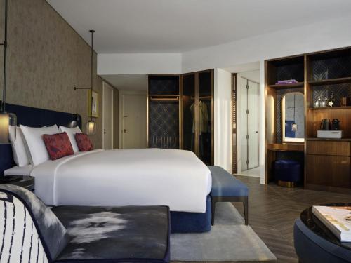a bedroom with a large white bed and a dressing room at SO/ Uptown Dubai in Dubai