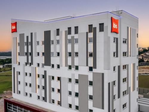 a rendering of a building with two red signs on it at Ibis Aruja in Arujá
