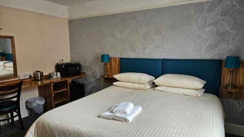 a bedroom with a bed with two towels on it at Edward Hotel in Gloucester