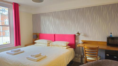a bedroom with a bed with two towels on it at Edward Hotel in Gloucester